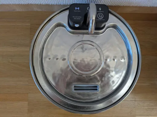 Trinkfläche des Edelstahl-Katzenbrunnens von oben mit Wasserauslass und Rücklauföffnung.